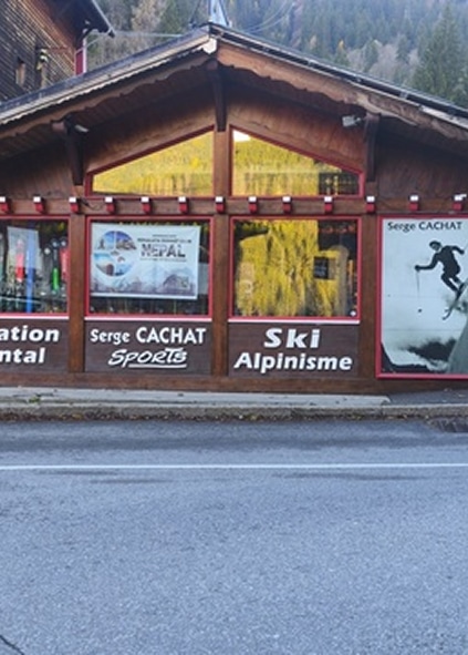 Façade du magasin Serge Cachat Sports en bois. Location de matériel, Ski Alpinisme. Services de montagne, affiche skieur et publicité Népal.